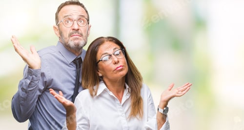 Preview: Middle Age Hispanic Couple In Love Wearing Glasses Over Isolated Background Clueless And Confused