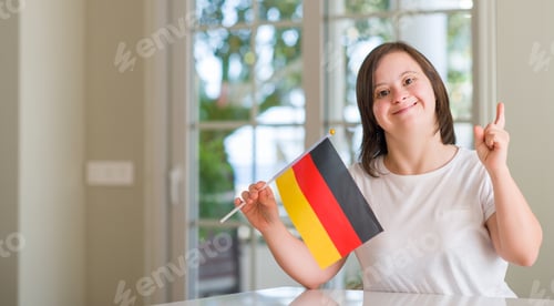 Preview: Down Syndrome Woman At Home Holding Flag Of Germany Surprised With An Idea Or Question Pointing