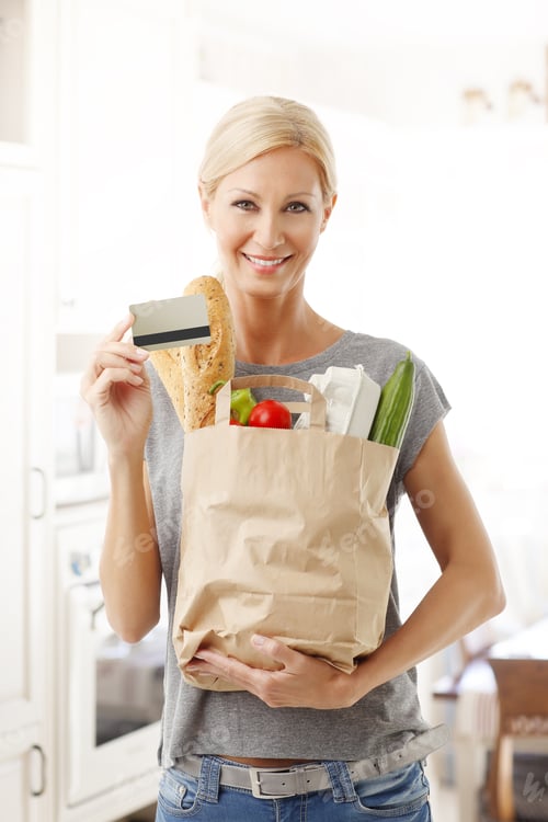 Preview: Portrait Of Smiling Woman Holding Hand Shopping Paper Bags Full Of Food While Other Hand There Is A