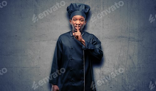 Preview: Young Black Cook Wearing Chef Hat With Index Finger On Lips, Ask To Be Quiet. Silence And Secret