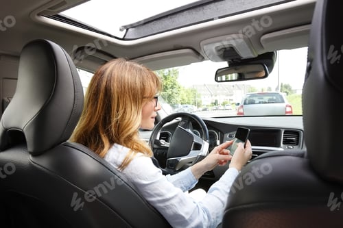 Preview: Portrait Of Reckless Driver Using Her Mobile Phone While Driving Car.