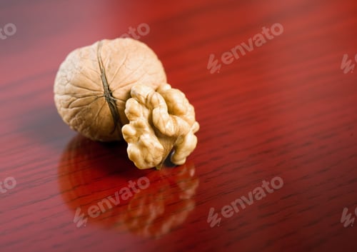Preview: Closeup Shot Of Tasty Healthy Walnut On Dark Red Wood Background.