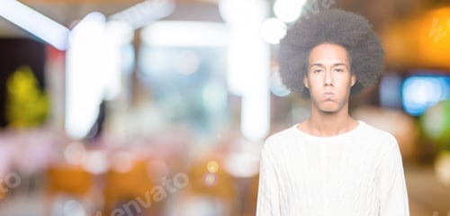 Preview: Young African American Man With Afro Hair Wearing Winter Sweater Puffing Cheeks With Funny Face