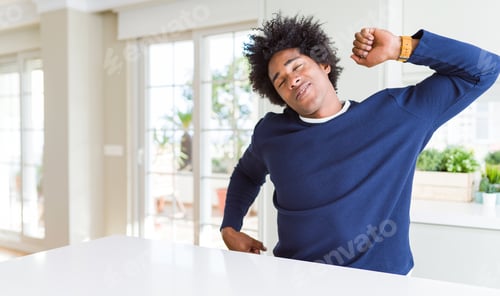 Preview: Young African American Man Wearing Casual Sweater Sitting At Home Stretching Back, Tired And