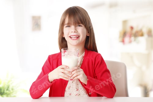 Preview: Portrait Of Adorable Little Girl Drinking A Glass Of Organic Juice While Sitting At Dining Table At