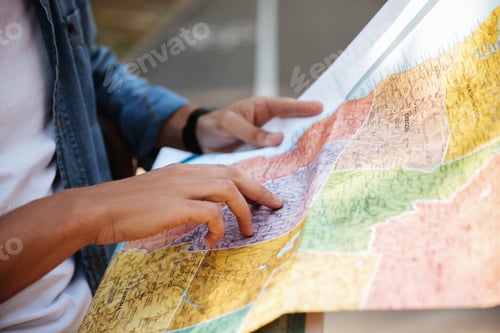 Preview: Cropped Image Of Young Man Looking At Map Outdoors.