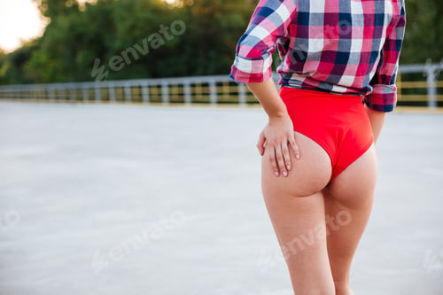 Preview: Cropped Image Of A Girl Butt In Red Swimsuit Posing On The Open Road Outdoors
