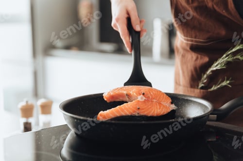 Preview: Cropped Picture Of Young Lady Standing In Kitchen While Cooking Fish.