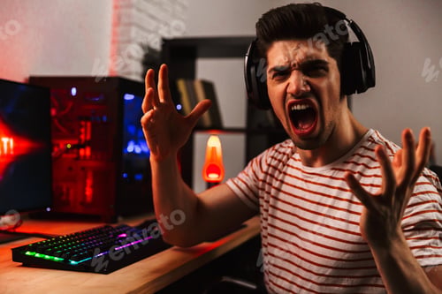 Preview: Side View Of Screaming Gamer Playing Video Games On Computer While Gesturing And Looking At The