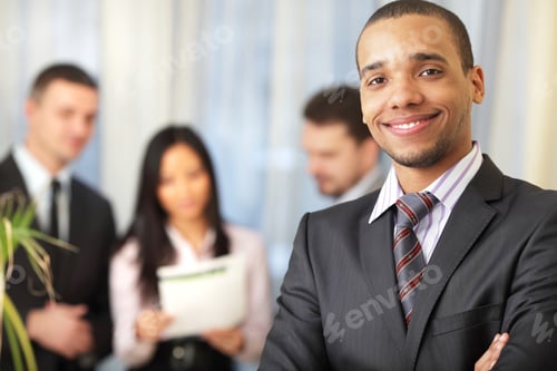 Preview: Happy African-American Businessman With His Team Working Behind