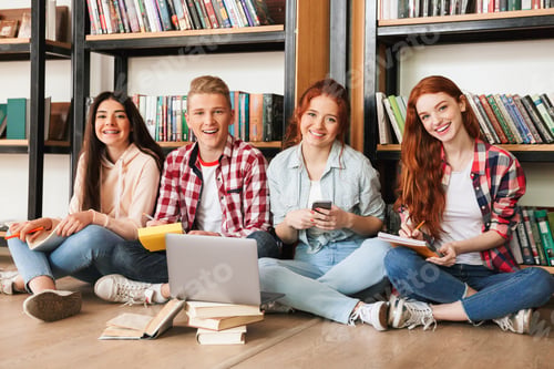 Preview: Group Of Smiling Teenagers Doing Homework While Sitting On A Floor At The Library With Laptop