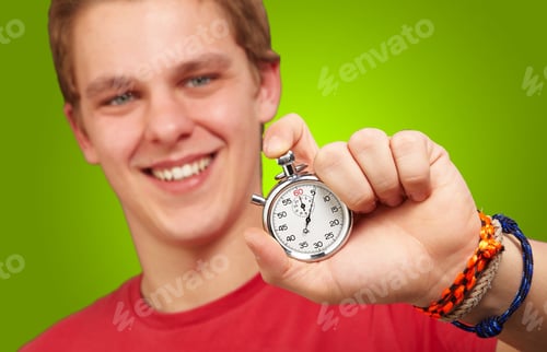 Preview: Portrait Of A Young Man Holding A Stopwatch On Green Background