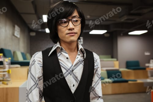 Preview: Photo Of Handsome Young Asian Man Wearing Glasses Dressed In Jacket And Shirt Standing Indoors And