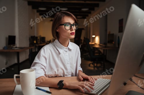 Preview: Pretty Young Businesswoman In Glasses Working And Typing On Computer In Office