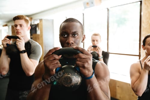 Preview: Picture Of Group Of Multiethnic Sports Strong People Make Sport Exercise With Weight. Looking Aside.