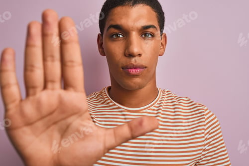 Preview: Young Handsome Arab Man Wearing Striped T-Shirt Standing Over Isolated Pink Background With Open