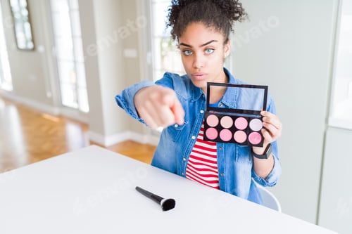 Preview: Young African American Woman Holding Cosmetics Blush Palette Pointing With Finger To The Camera And