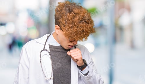 Preview: Young Handsome Doctor Man Wearing Medical Coat Feeling Unwell And Coughing As Symptom For Cold Or