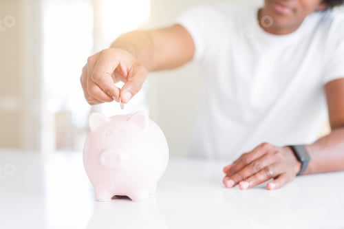 Preview: Close Up Of African American Man Saving Money Putting A Coin Inside Piggy Bank