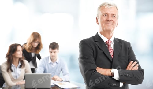 Preview: Executive Businessman Standing At Office While Business People Working On Laptop At Background