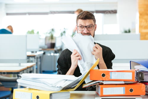 Preview: Young Businessman Biting Paper In Office