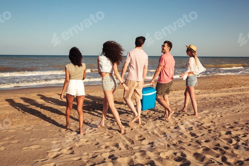 Preview: Group Of Cheerful Young Friends In Summer Clothes Going For A Picnic At The Beach