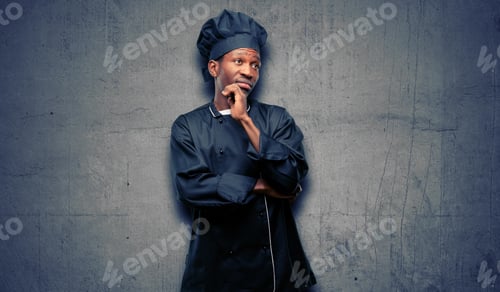 Preview: Young Black Cook Wearing Chef Hat Thinking And Looking Up Expressing Doubt And Wonder