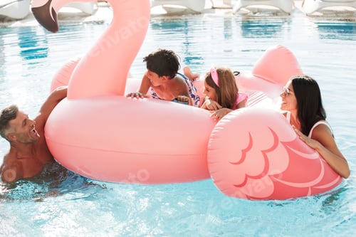 Preview: Portrait Of Beautiful Joyous Woman And Man With Kids Swimming In Pool With Pink Rubber Ring Outside