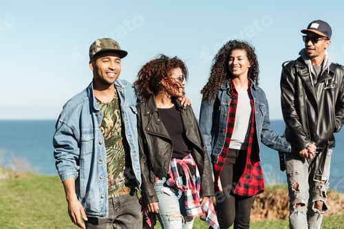 Preview: Picture Of A Group Of African Friends Walking Outdoors Near Beach. Looking Aside.