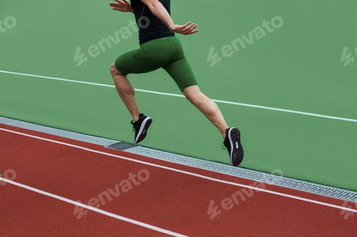 Preview: Cropped Image Of Young Caucasian Athlete Man Run On Running Track Outdoors.
