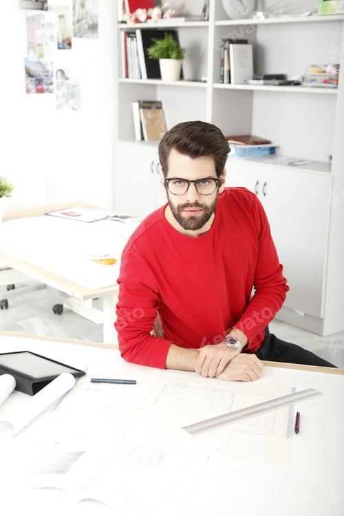Preview: Young Businessman Sitting At Desk And Working In Small Architect Studio.