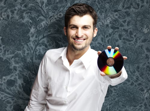 Preview: Portrait Of A Handsome Young Man Holding Cd Against A Vintage Wall