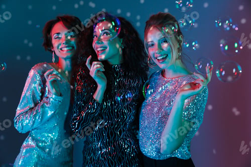 Preview: Three Cheerful Beautiful Women Wearing Bright Clothes Having A Party Over Sparkling Background