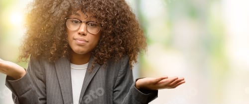 Preview: African American Business Woman Wearing Glasses Clueless And Confused Expression With Arms And