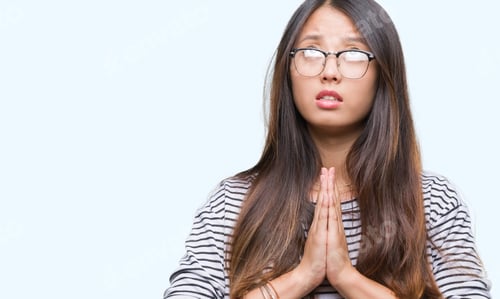 Preview: Young Asian Woman Wearing Glasses Over Isolated Background Begging And Praying With Hands Together