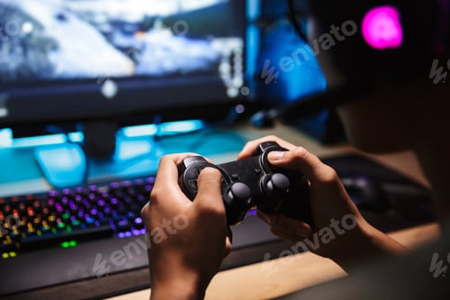 Preview: Photo Closeup Of Asian Gamer Boy Playing Video Games Online On Computer In Dark Room Wearing