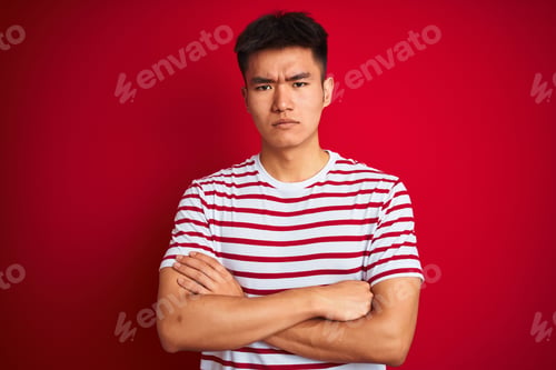 Preview: Young Asian Chinese Man Wearing Striped T-Shirt Standing Over Isolated Red Background Skeptic And