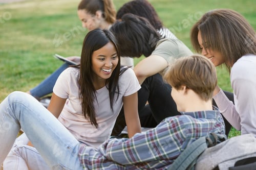 Preview: Picture Of Multiethnic Group Of Happy Young Students Sitting Studying Outdoors. Looking Aside.