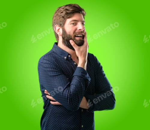 Preview: Young Hipster Man With Big Beard Happy And Surprised Cheering Expressing Wow Gesture Over Green