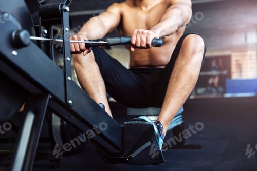 Preview: Cropped Image Of A Fitness Man Using Rowing Machine In The Gym