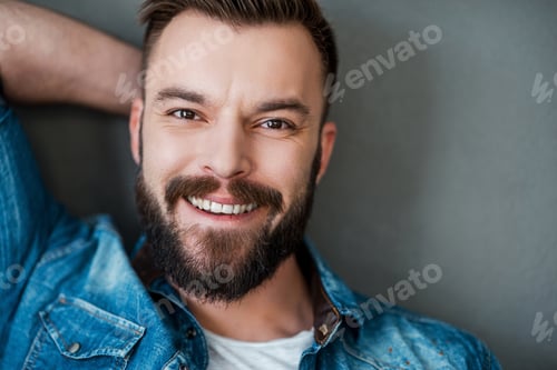Preview: Happiness Never Goes Out Of Style. Cheerful Young Man Holding Hand Behind Head And Smiling At
