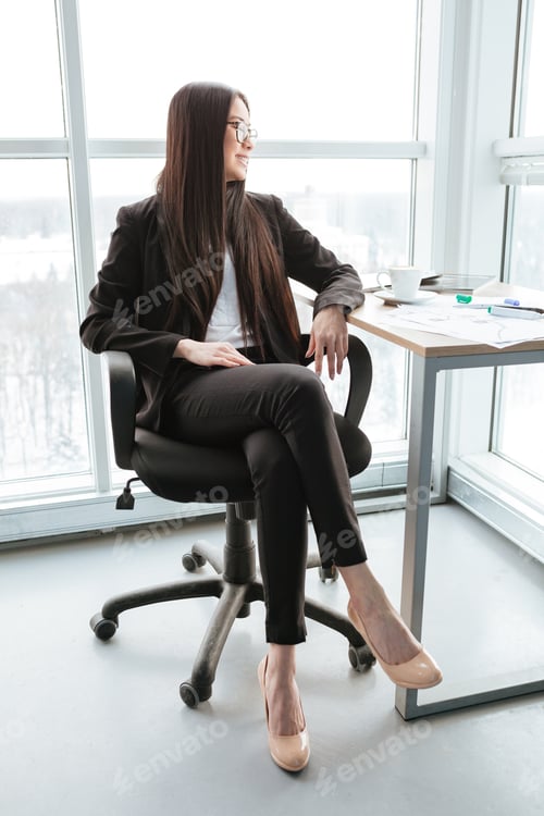 Preview: Cheerful Attractive Asian Young Businesswoman Sitting And Drinking Coffee In Office