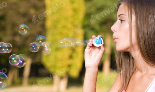 Preview: Dreamy Blond Teen Beauty Blowing Soap Bubbles.