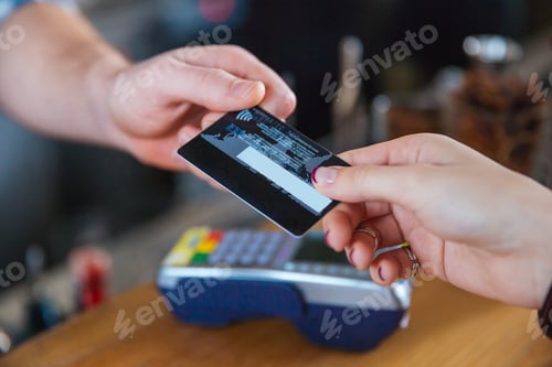 Preview: Closeup Of Two Hands Holding Credit Card For Paying With Reader