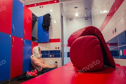 Preview: Tired Man Sitting On The Floor In The Locker Room After Finishing Training