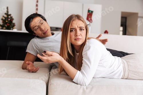 Preview: Image Of Perplexed Couple Man And Woman Arguing While Lying Together In Bed In Apartment