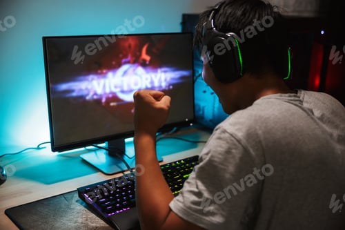 Preview: Portrait Of Happy Teenage Gamer Boy Winning While Playing Video Games On Computer In Dark Room