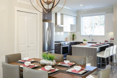 Preview: Modern Dining Room Table With Plates And Bowls In A House, Hotel With A Kitchen In The Background