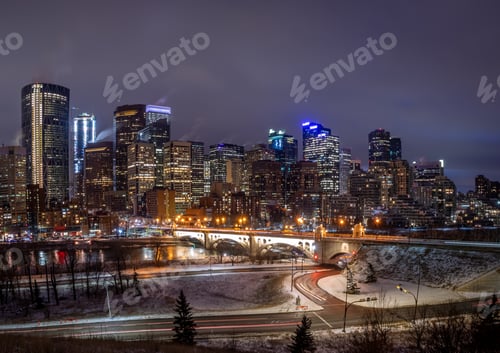 Preview: View Of Calgary'S Skyline On A Cool Evening In Winter. Bow River Is Visible In The Foreground.