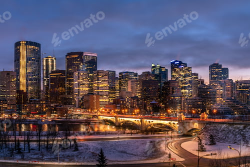 Preview: View Of Calgary'S Skyline On A Cool Evening In Winter. Bow River Is Visible In The Foreground.